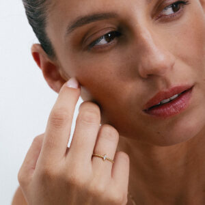 Anel com aro torcido em ouro 18k e diamante navete vestido em uma mão feminina