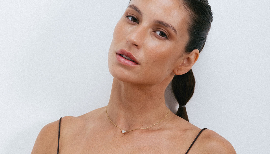 Modelo com colar delicado em ouro 18k e diamante lapidação gota.