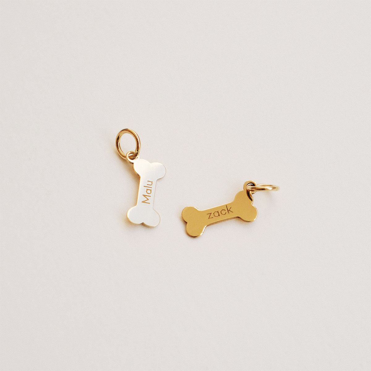 Pingentes em formato de ossinho personalizados com nomes gravados em ouro 18k