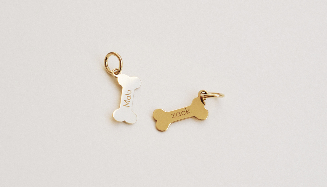 Pingentes em formato de ossinho personalizados com nomes gravados em ouro 18k.