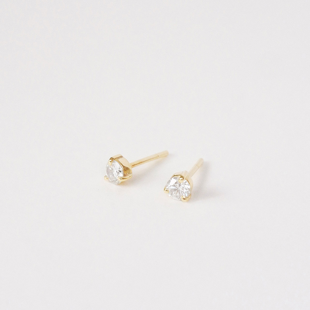 Par de brincos stud em ouro amarelo 18k com diamantes de 20 pontos.