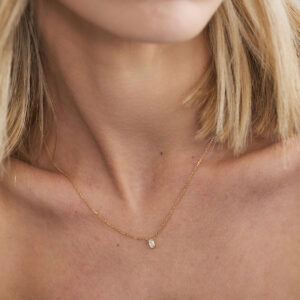 Colar solitário com diamante oval em ouro 18k sendo usado.