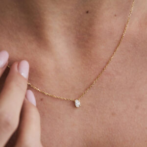 Colar solitário em ouro 18k com diamante oval em detalhe no colo.