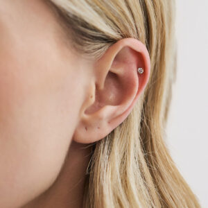 Close do Piercing Diamante em ouro 18k com diamante redondo aplicado na cartilagem da orelha, na região do hélix (helix).