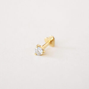Piercing Diamante em ouro amarelo 18k com diamante redondo fotografado sobre fundo off-white.