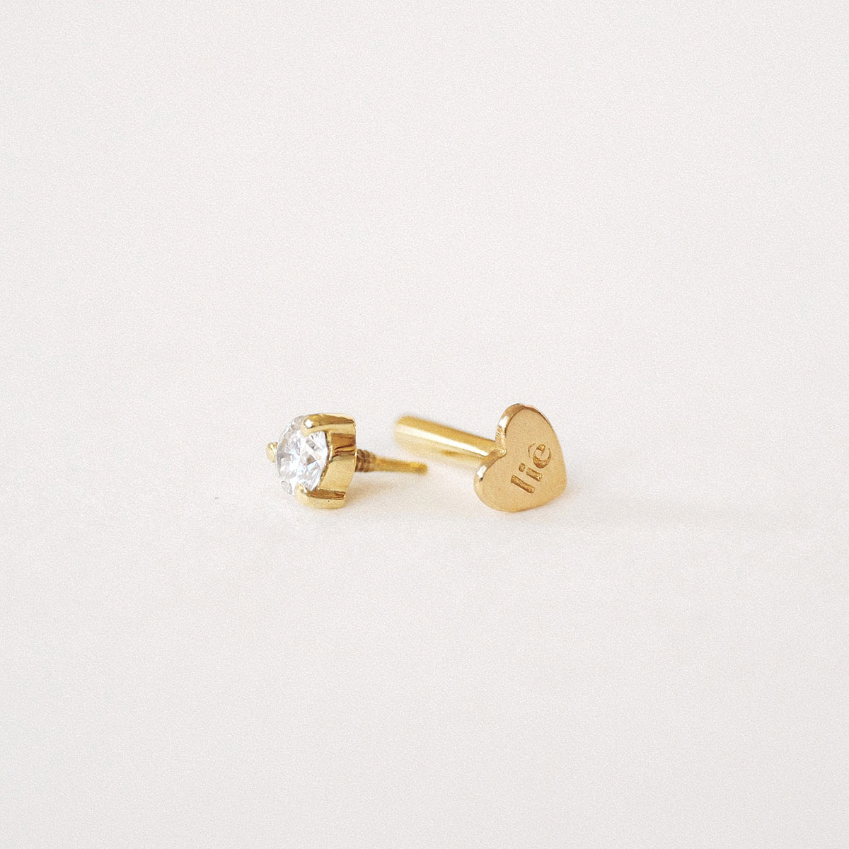 Verso do Piercing Diamante em ouro 18k mostrando o sistema de rosca interna e a tarraxa em formato de coração.