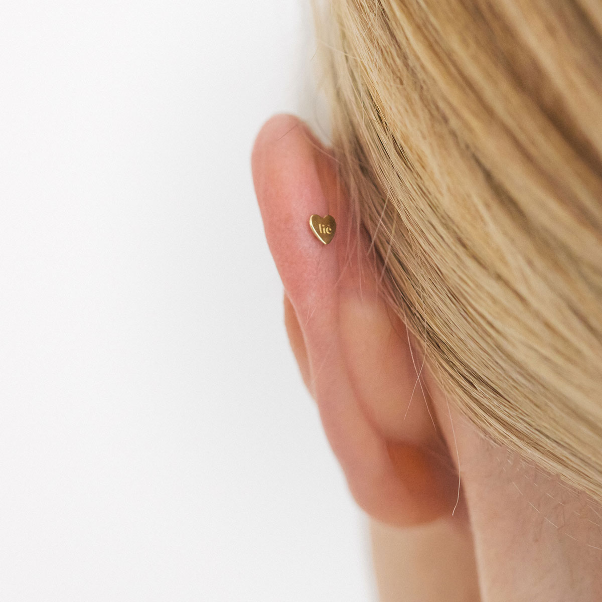 Verso do Piercing Gota em ouro 18k mostrando a tarraxa em formato de coração.