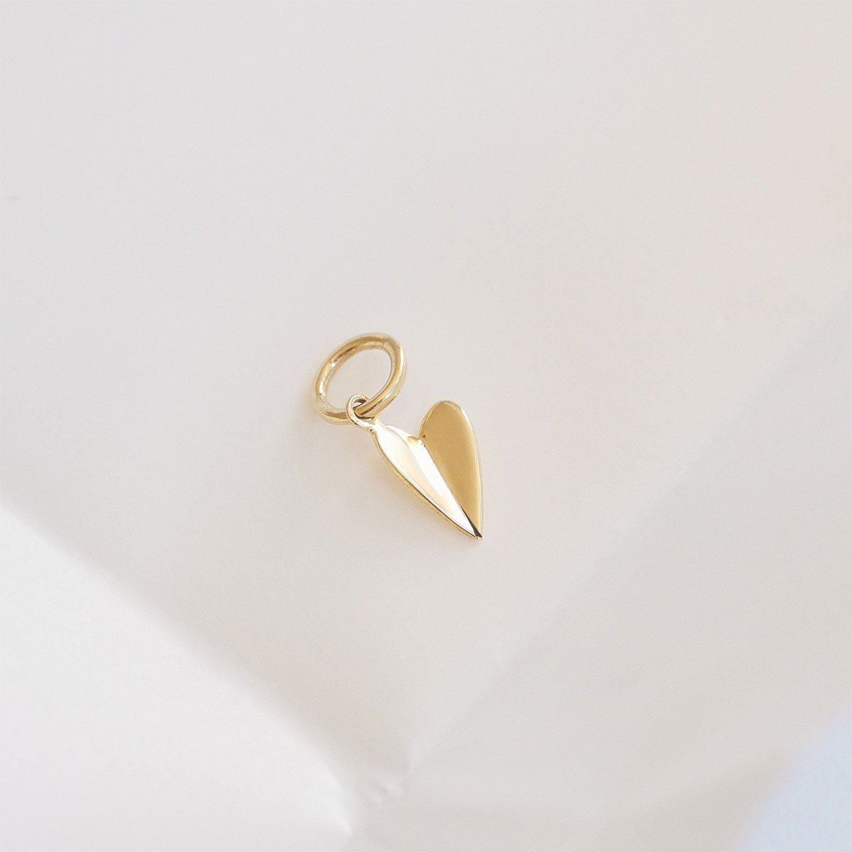 Pingente de coração em ouro com design minimalista e formato dobrado