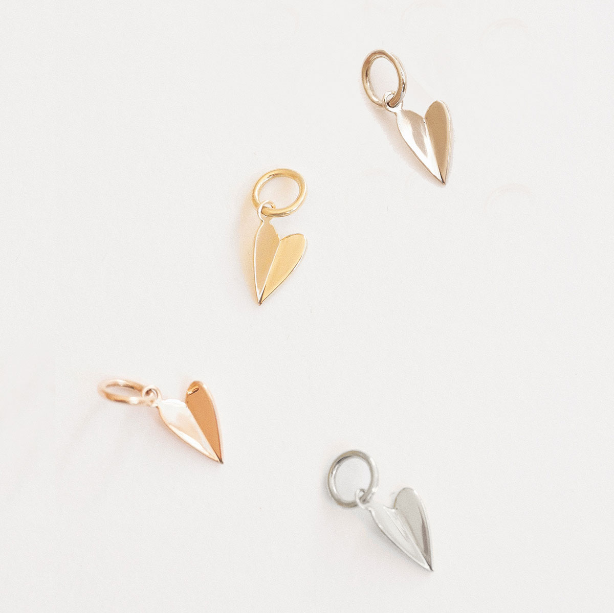 Pingentes Dobra Coração em ouro 18k com design minimalista em diferentes variações