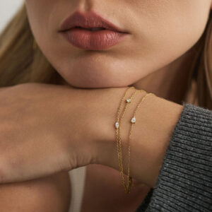 Modelo usando pulseiras em ouro 18k com diamantes em composição.
