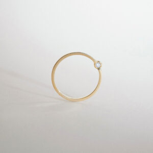 O Anel Órbita em ouro 18k traz um design minimalista e contemporâneo, com diamante deslocado do centro tradicional para criar uma composição leve, precisa e fora do óbvio.