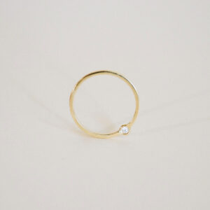 O Anel Órbita em ouro 18k traz um design minimalista e contemporâneo, com diamante deslocado do centro tradicional para criar uma composição leve, precisa e fora do óbvio.