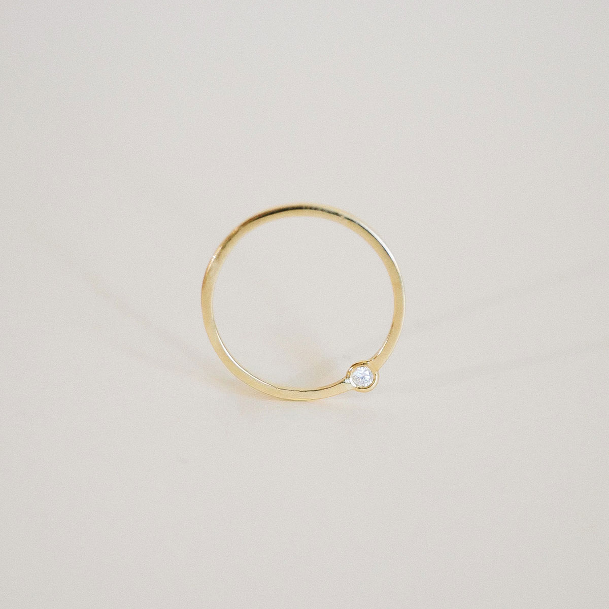 O Anel Órbita em ouro 18k traz um design minimalista e contemporâneo, com diamante deslocado do centro tradicional para criar uma composição leve, precisa e fora do óbvio.