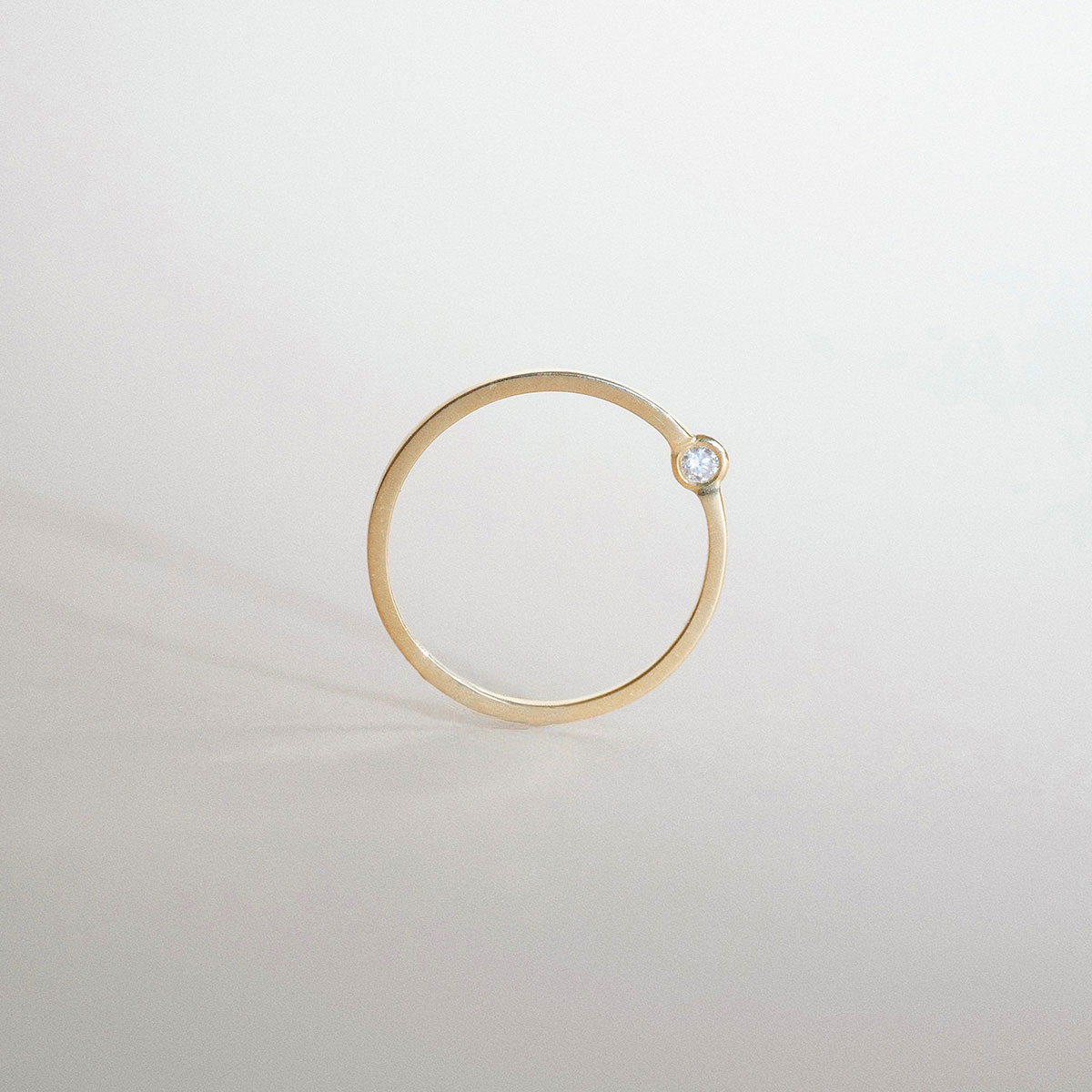 O Anel Órbita em ouro 18k traz um design minimalista e contemporâneo, com diamante deslocado do centro tradicional para criar uma composição leve, precisa e fora do óbvio.