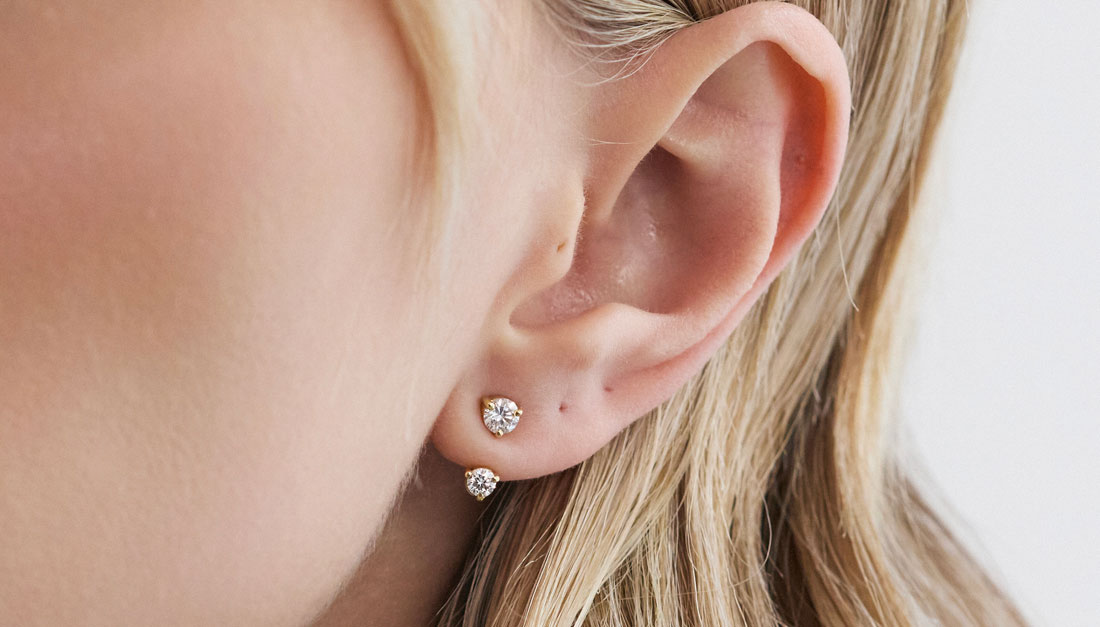 Modelo usando o Ear Jacket Dot em ouro 18k com diamante combinado a um brinco stud.