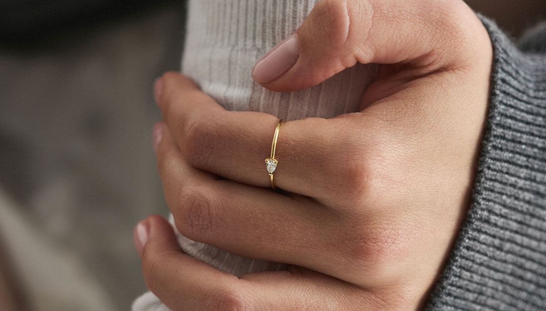 Modelo usando anel em ouro 18k com diamante lapidação gota na horizontal.