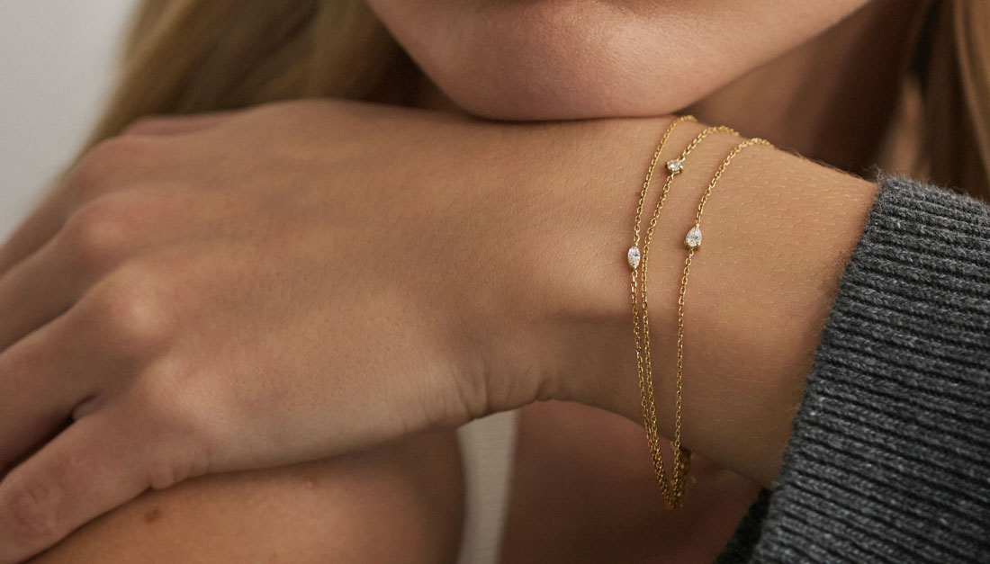 Modelo usando pulseiras em ouro 18k com diamantes nas lapidações brlhante, gota e navete.