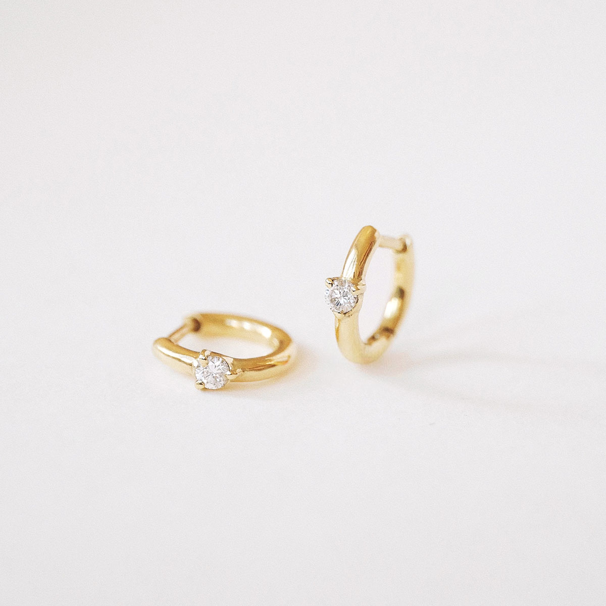 Par de Brincos Huggie Ponto em ouro amarelo 18k com diamantes.