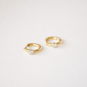 Close do Brinco Huggie Ponto em ouro 18k com diamante.