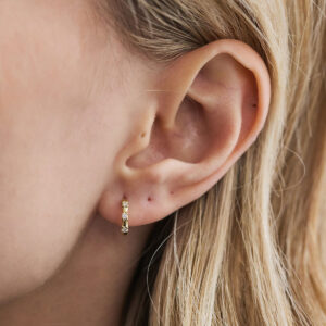 Close do Brinco Trio Huggie em ouro 18k com três diamantes naturais.