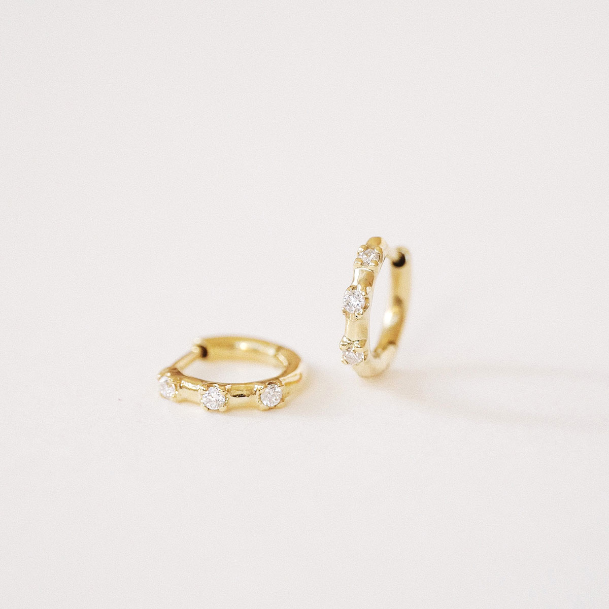 Par de Brincos Trio Huggie em ouro branco 18k com três diamantes.