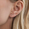 Modelo usando o Brinco Linha em ouro 18k, brinco threader com corrente e diamante de 5 pontos.