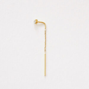 Brinco Linha (threader) em ouro amarelo 18k com diamante de 5 pontos e corrente delicada, fotografado sobre fundo off-white.