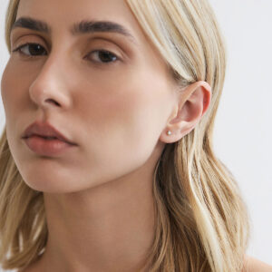 Modelo usando brinco stud de diamante de 10 pontos em ouro 18k.