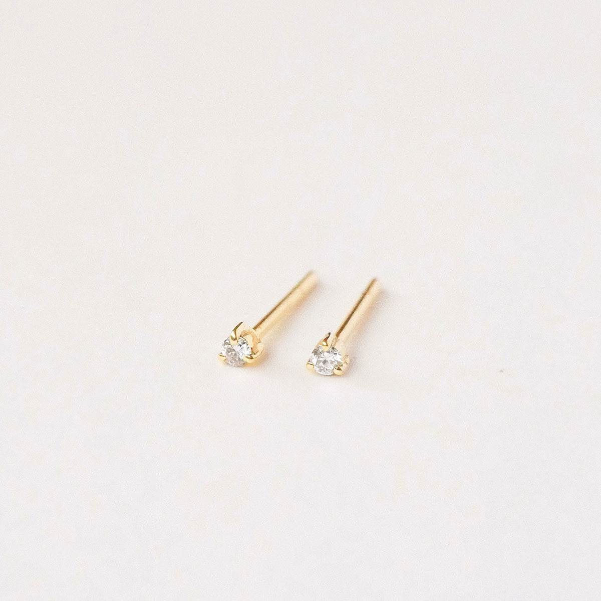 Par de brincos stud em ouro amarelo 18k com diamantes de 2 pontos.