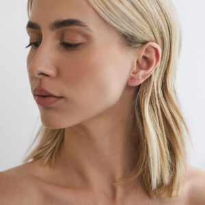 Modelo usando brinco stud de diamante de 2 pontos em ouro 18k.