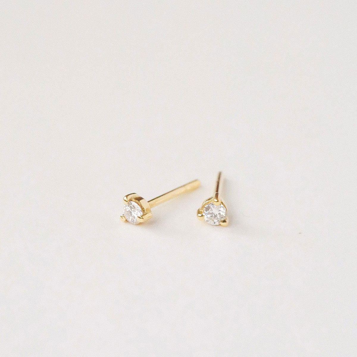 Par de brincos stud em ouro amarelo 18k com diamantes de 5 pontos.