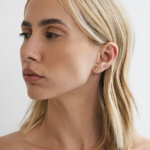 Modelo usando brinco stud de diamante de 5 pontos em ouro 18k.