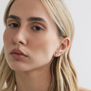 Modelo usando composição com brincos stud de diamante de 20, 5 e 2 pontos em ouro 18k.