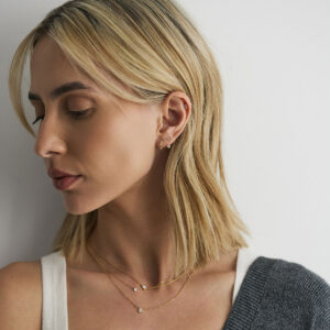 Modelo usando Ear Jacket Dot em ouro 18k com diamantes, studs, piercing, huggie e colares de diamante.